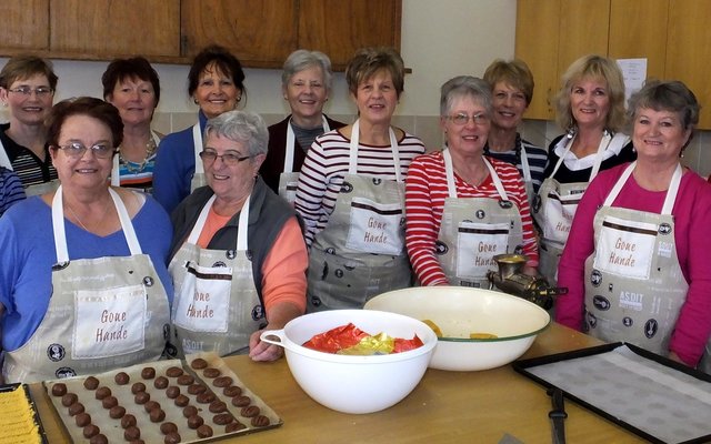 Die Goue Hande se dames staan “kosbare” tyd af vir ‘n foto om so gou moontlik weer met die dosyne koekies aan te gaan - spoggerig met hul pragtige “Goue Hande” voorskote